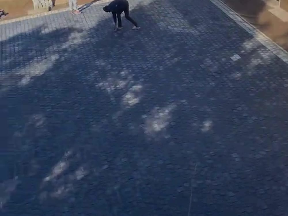 Dark paved courtyard and driveway wrapping around a poolside home