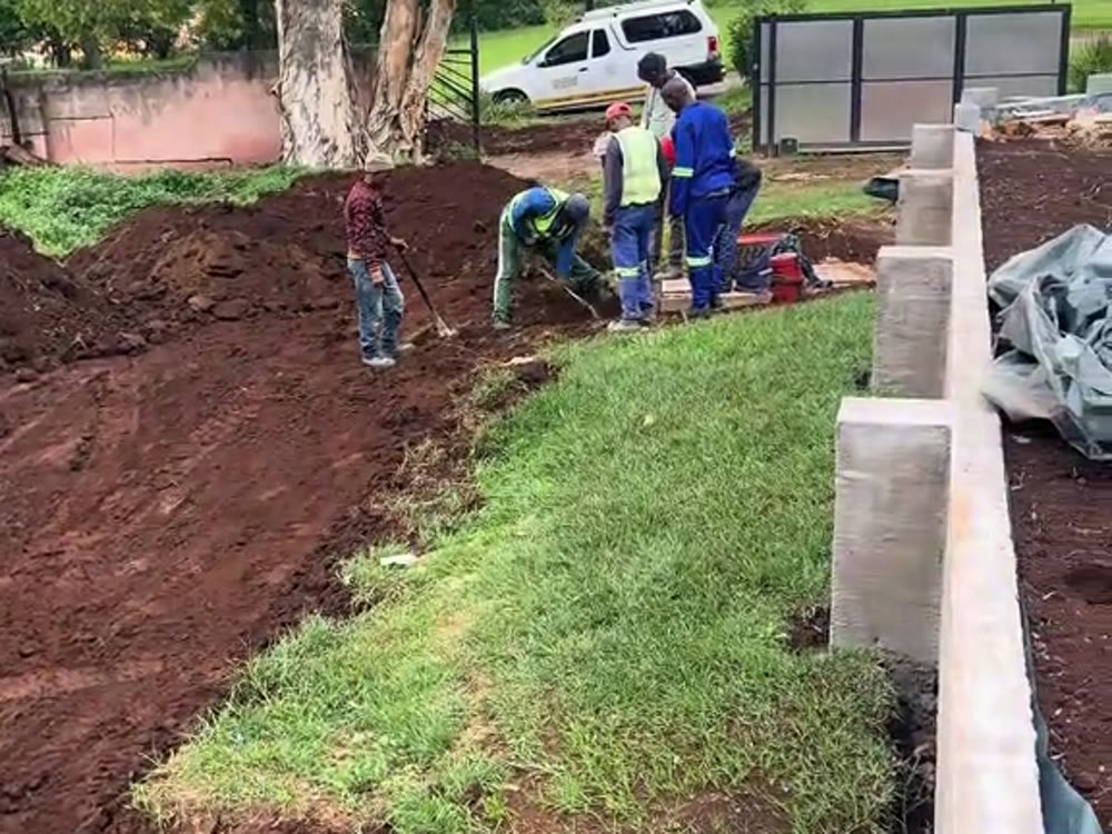 Block retaining wall being built into a graded slope